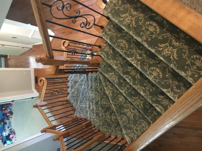 Green carpet runner on hardwood stairs